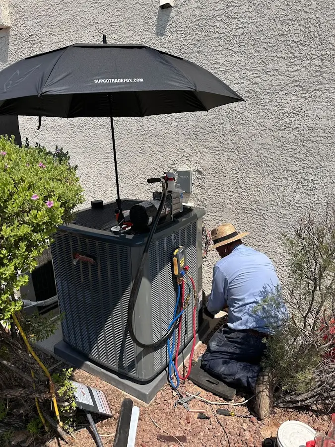 HVAC technician performing outdoor AC maintenance in Fairmount
