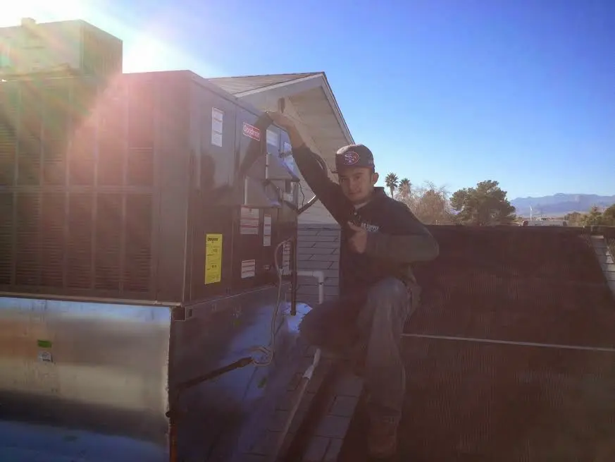 HVAC technician performing HVAC Inspection on a rooftop unit in Fairmount